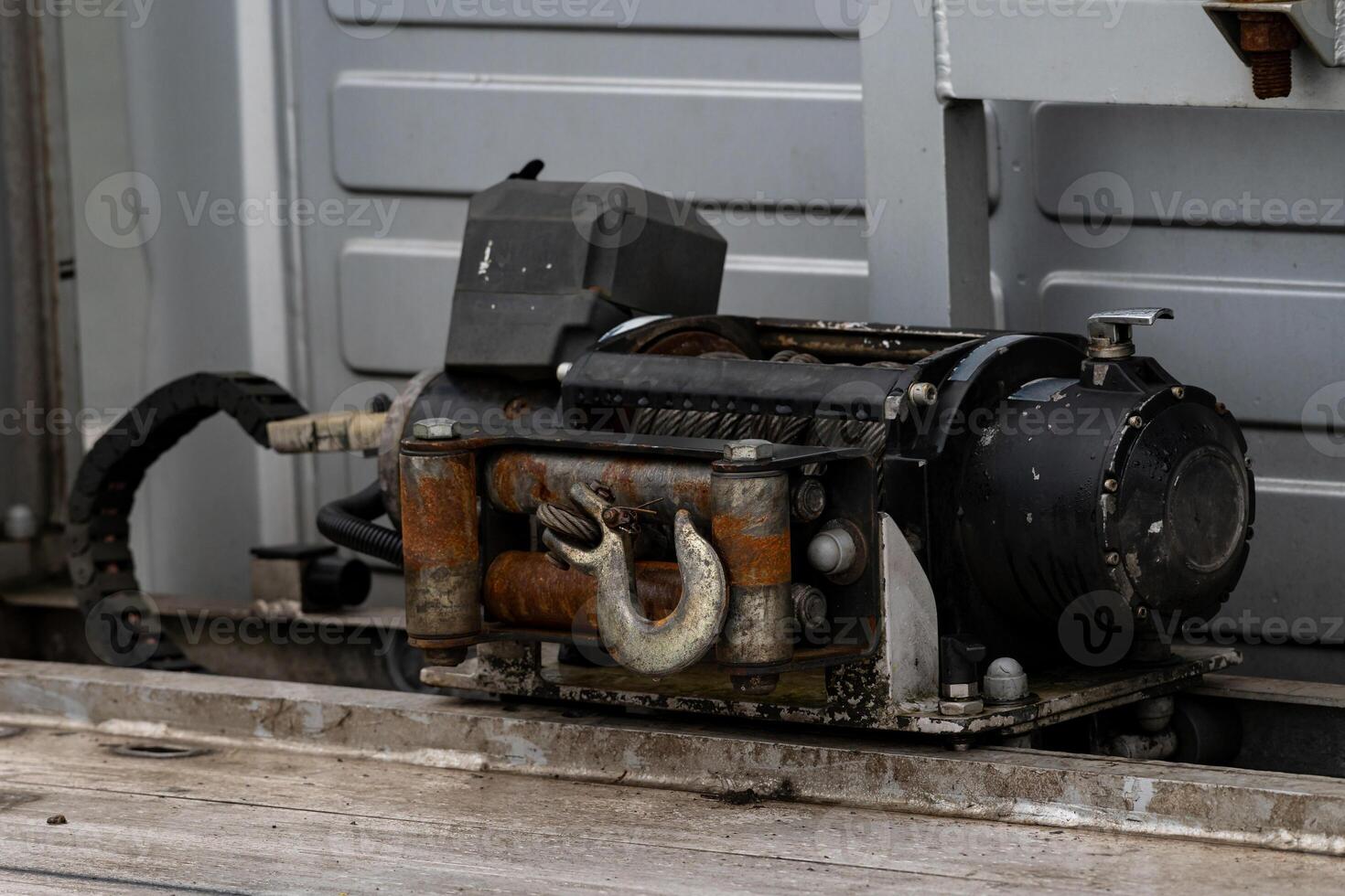 Electric winch with a metal hook in the body of a car. photo