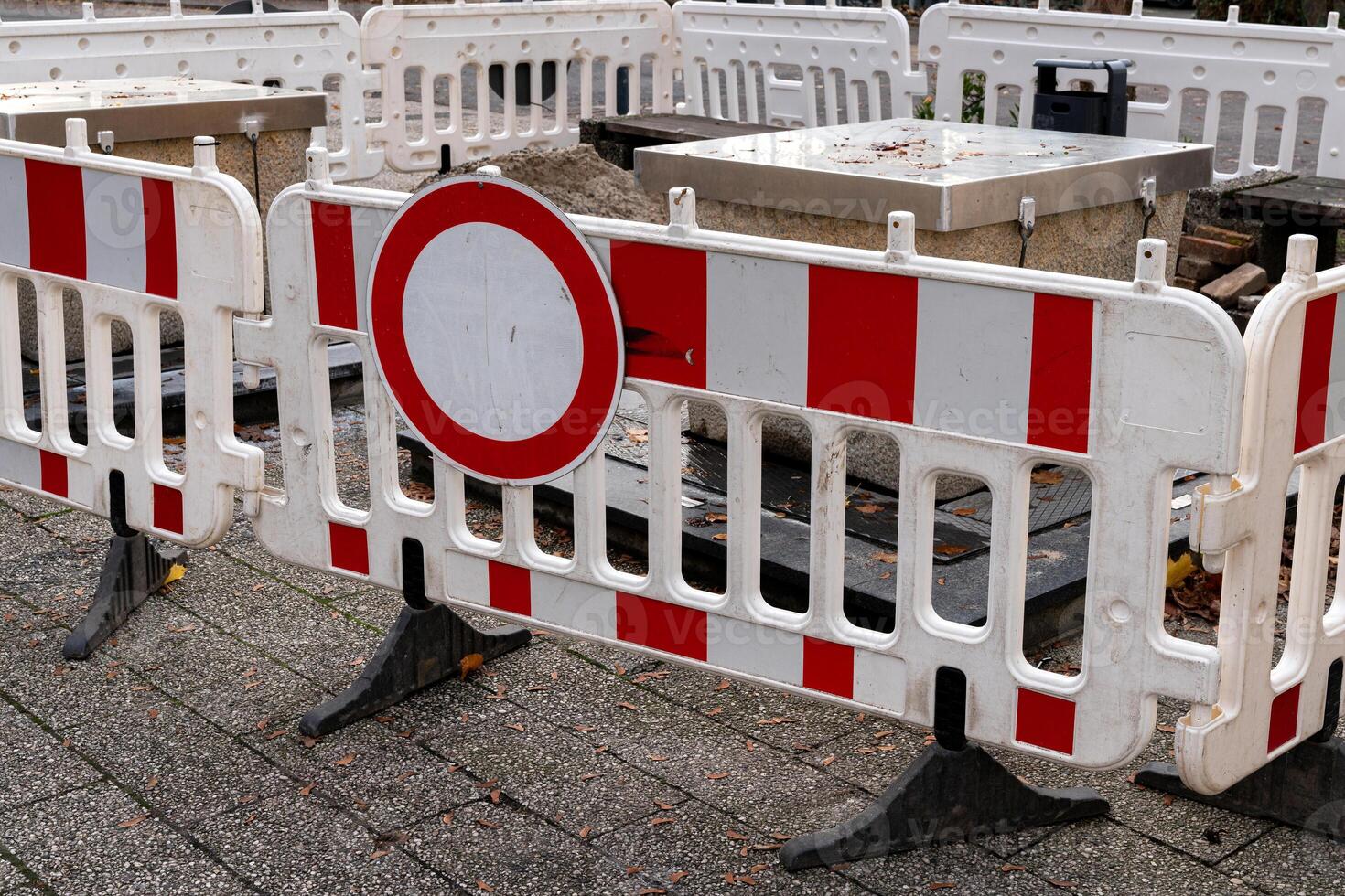 Red and white barriers restrict access to a construction site in an photo