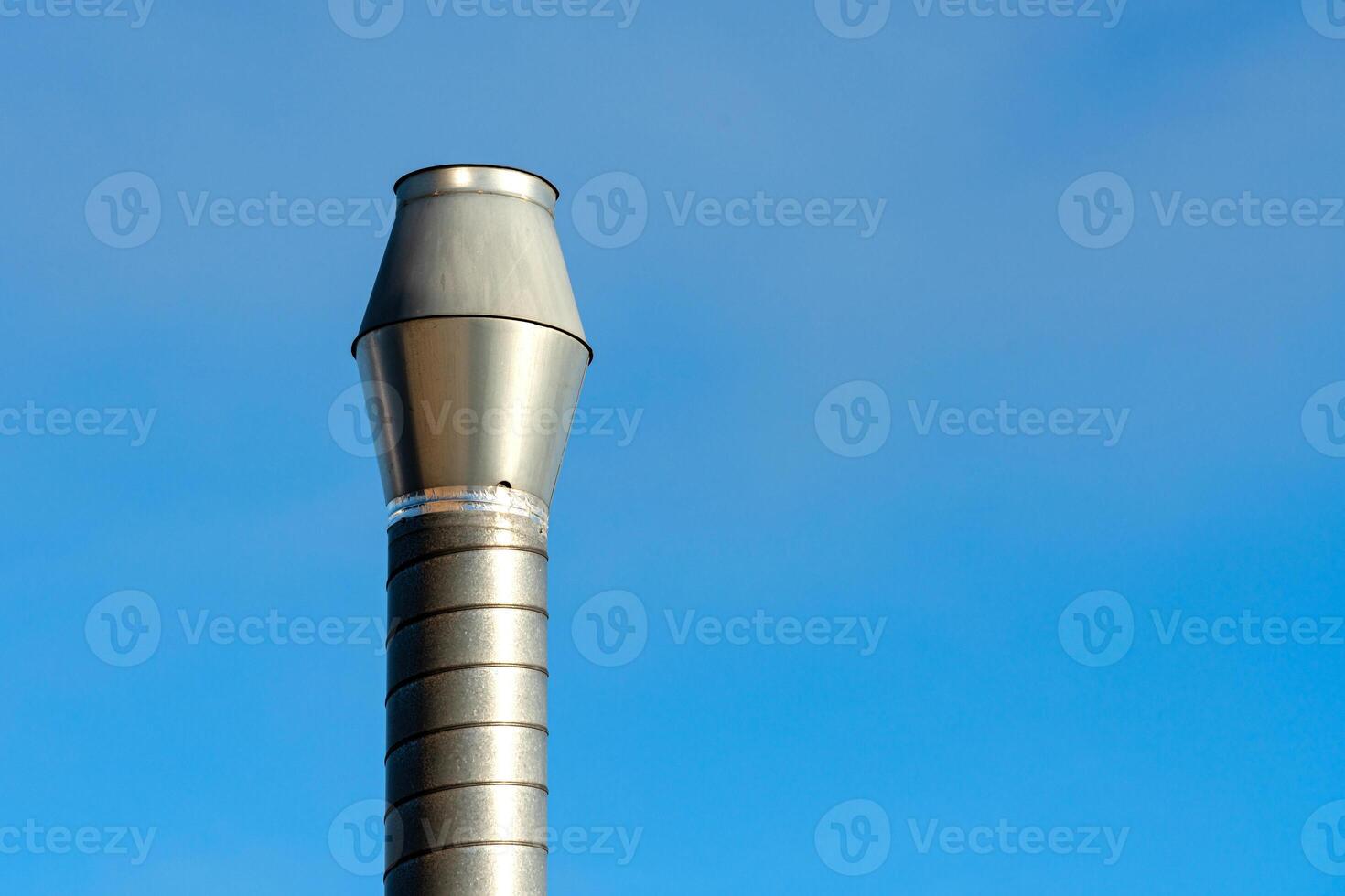 Metal chimney cap against clear blue sky in daylight photo