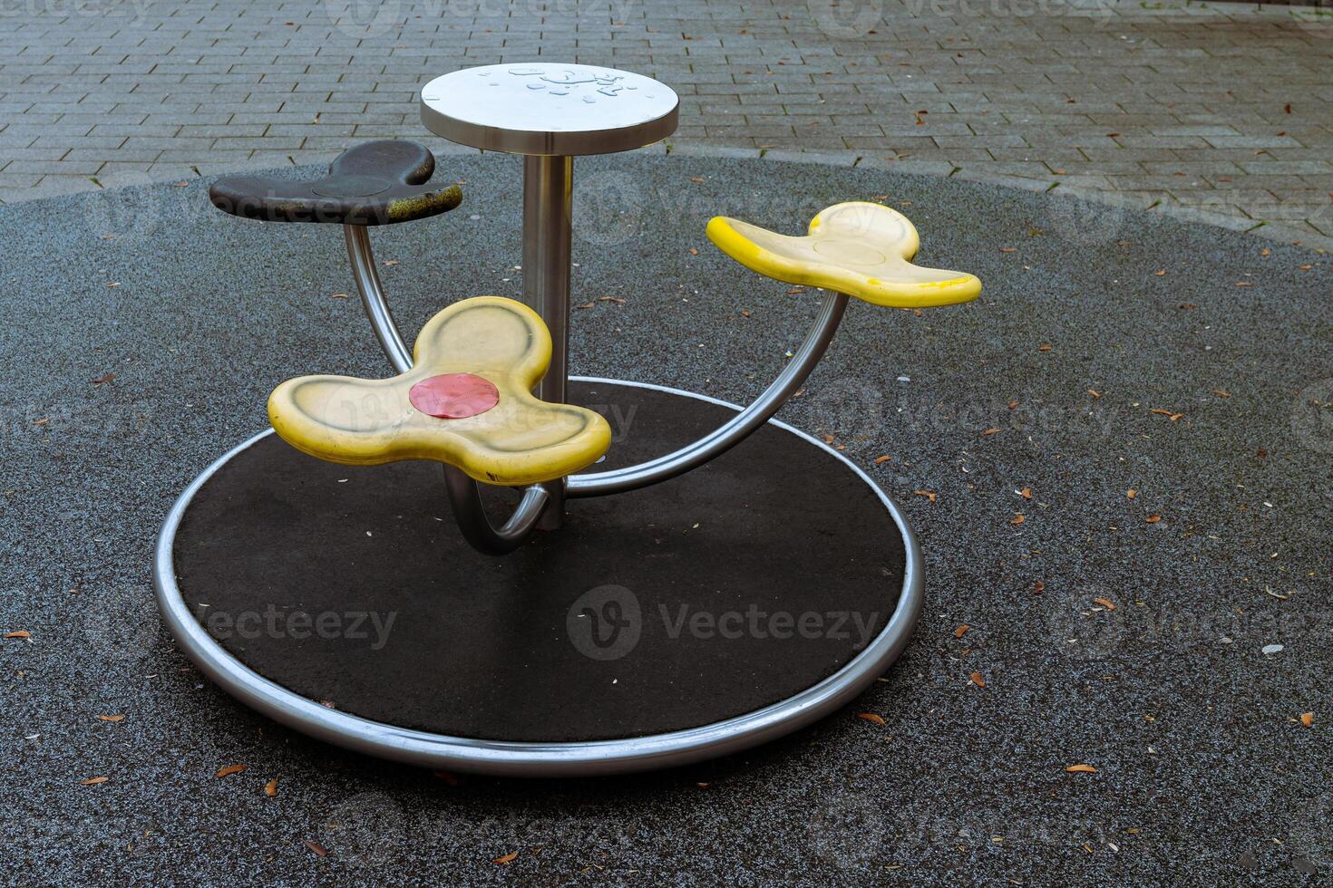 A colorful playground spinner designed for young children is situated photo