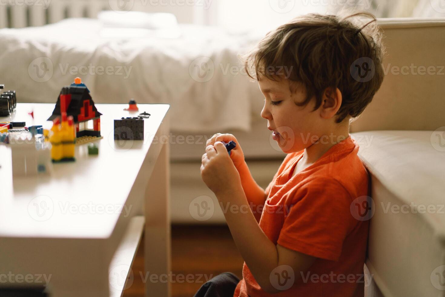 Cute boy is playing constructor at home. Kid playing block toys in home at nursery. photo