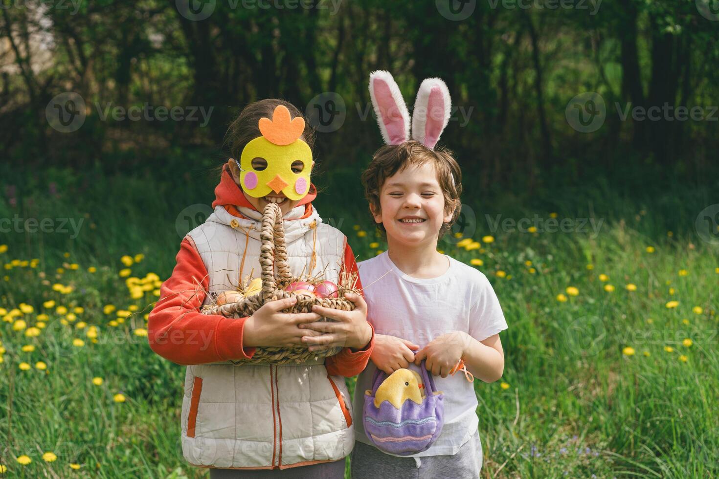 Two children hunt for Easter eggs in a spring garden. Easter tradition photo