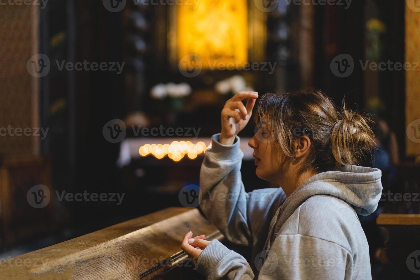 Woman praying on her knees in an ancient Catholic temple to God. photo