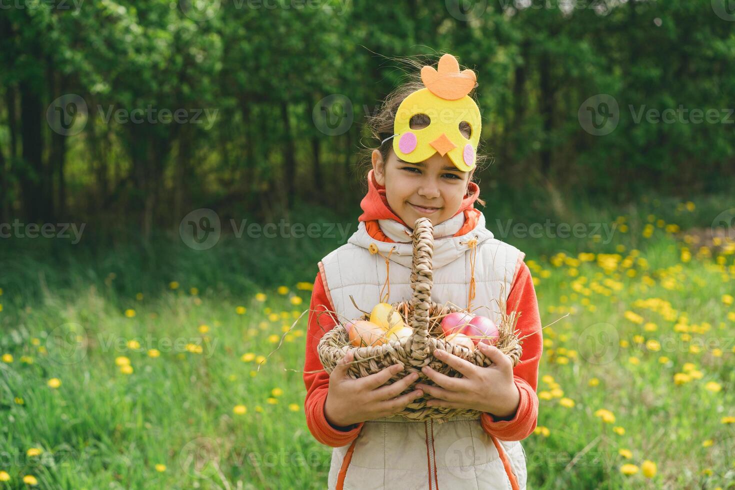 Girl with eggs basket and with a chicken mask on Easter egg hunt photo