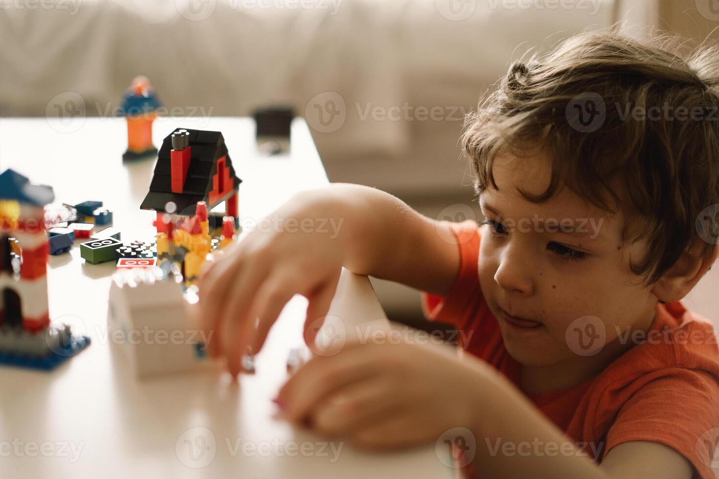 Cute boy is playing constructor at home. Kid playing block toys in home at nursery. photo