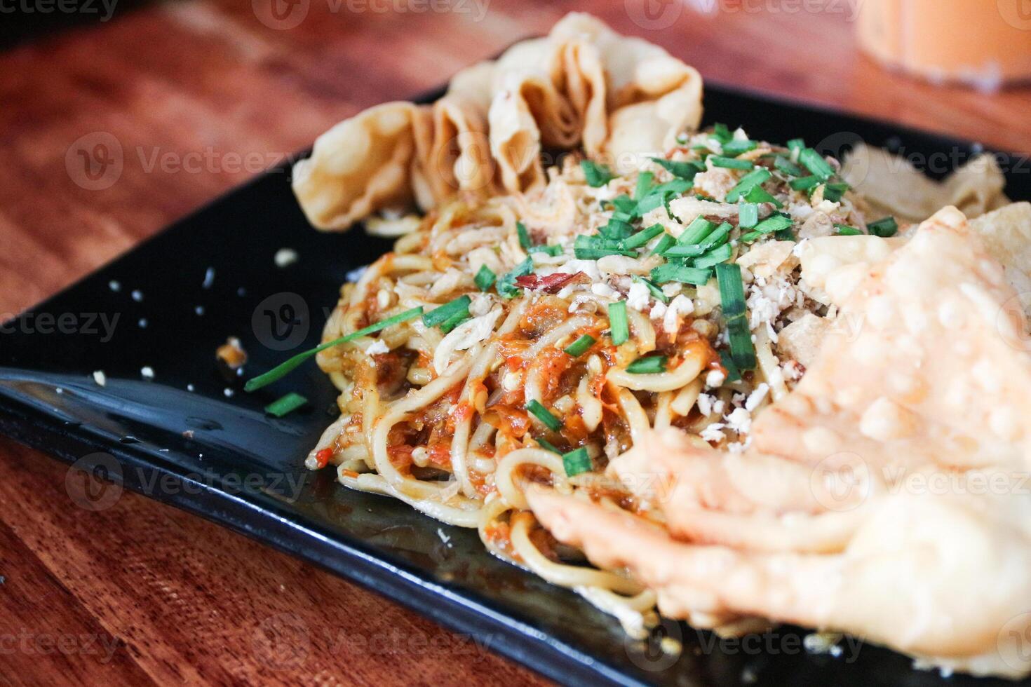 Gacoan noodles are a popular food in Indonesia. Made from noodles served with spicy spices and fried dumplings. photo
