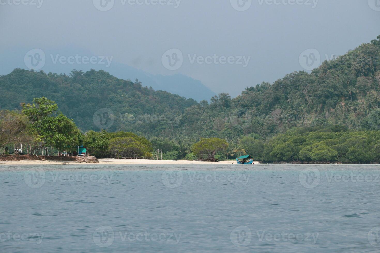 Traditional blue wooden boat heading to the resort in Pahawang during summer holidays photo