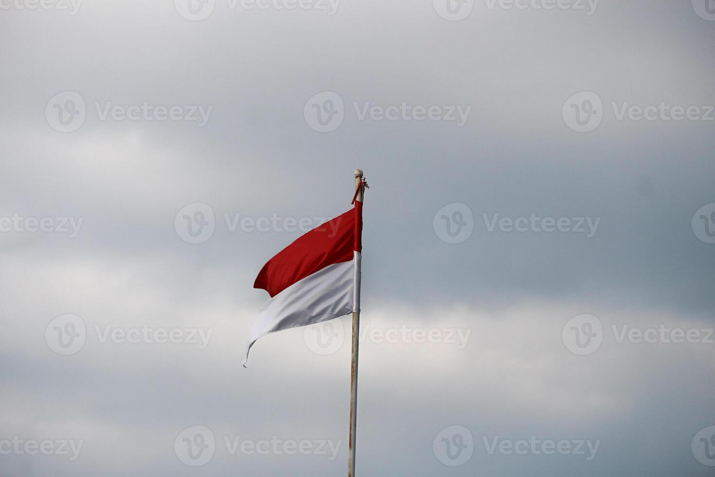 Indonesian flag fluttering in the wind with dark clouds in the background. photo