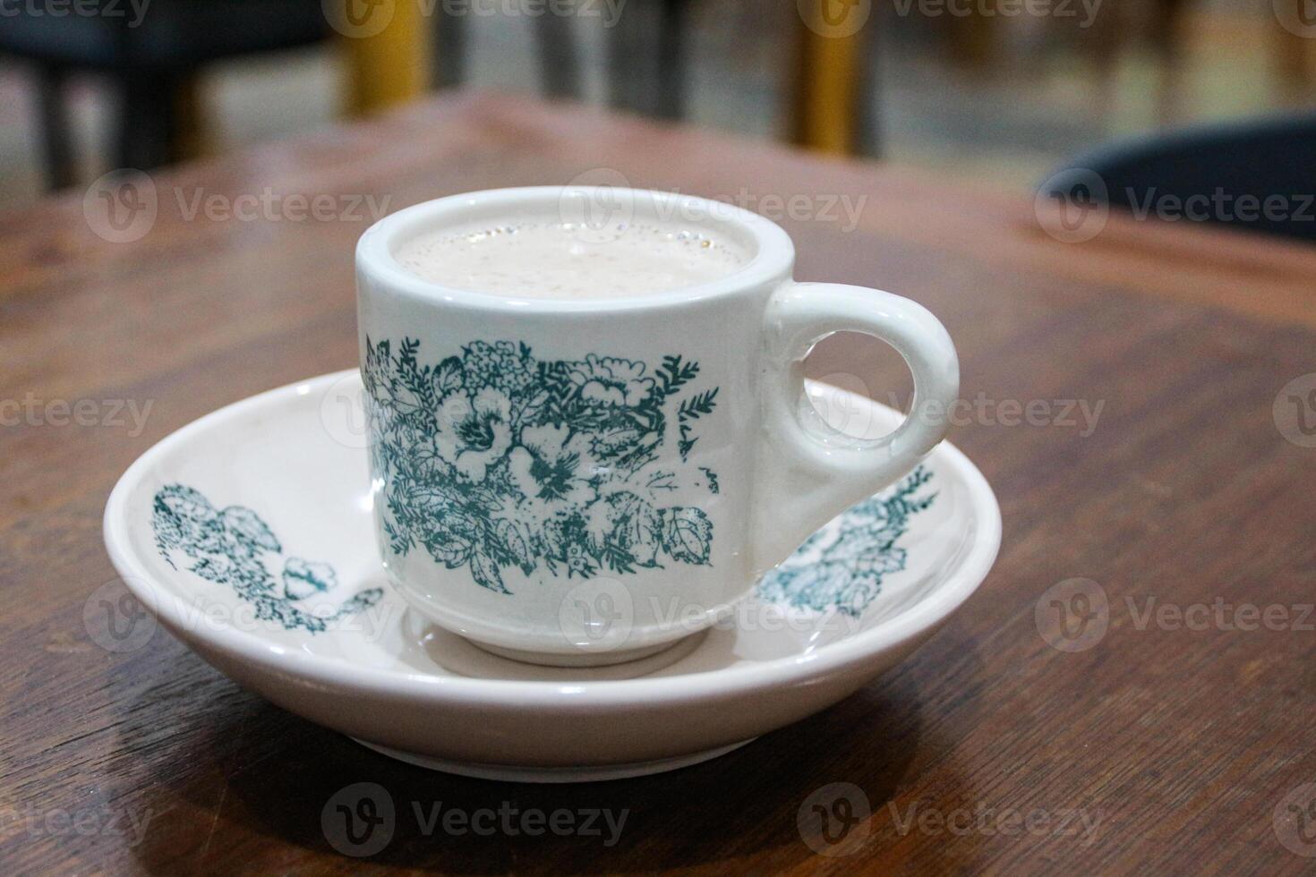 Hot coffee latte with latte art milk foam in cup mug on wood desk on top view. As breakfast In a coffee shop at the cafe,during business work concept,vintage style photo