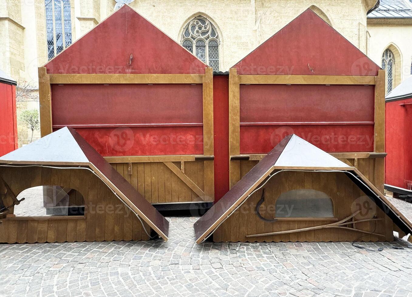Empty market stalls with red tarps and collapsed booths in a historic setting photo