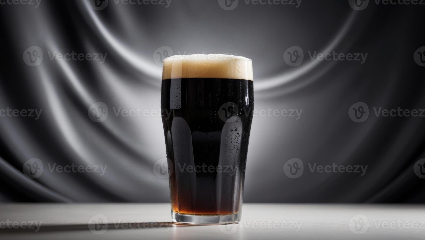A dark beer in a glass on a table photo