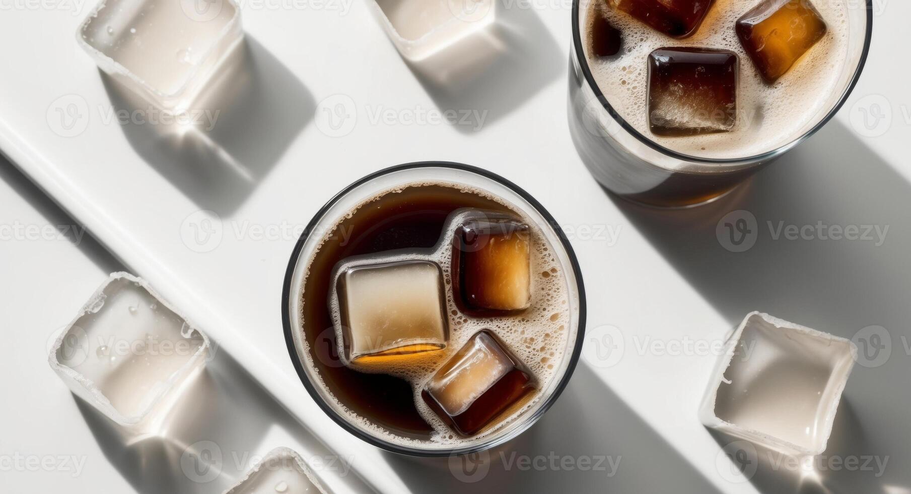 Two glasses of cola with ice cubes on a white surface photo