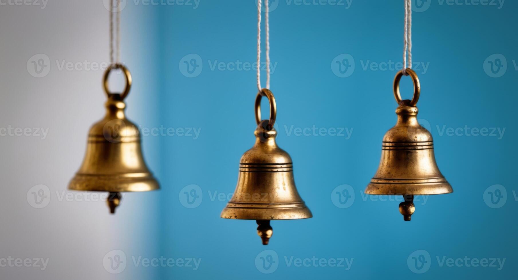 Three brass bells hanging from strings photo