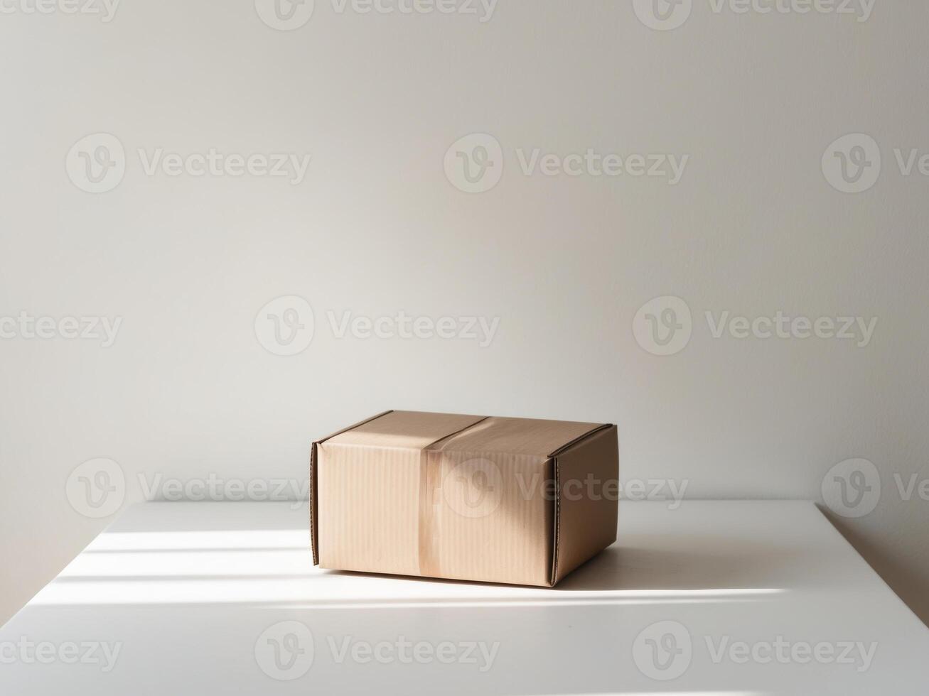 A cardboard box sitting on a table in front of a white wall photo