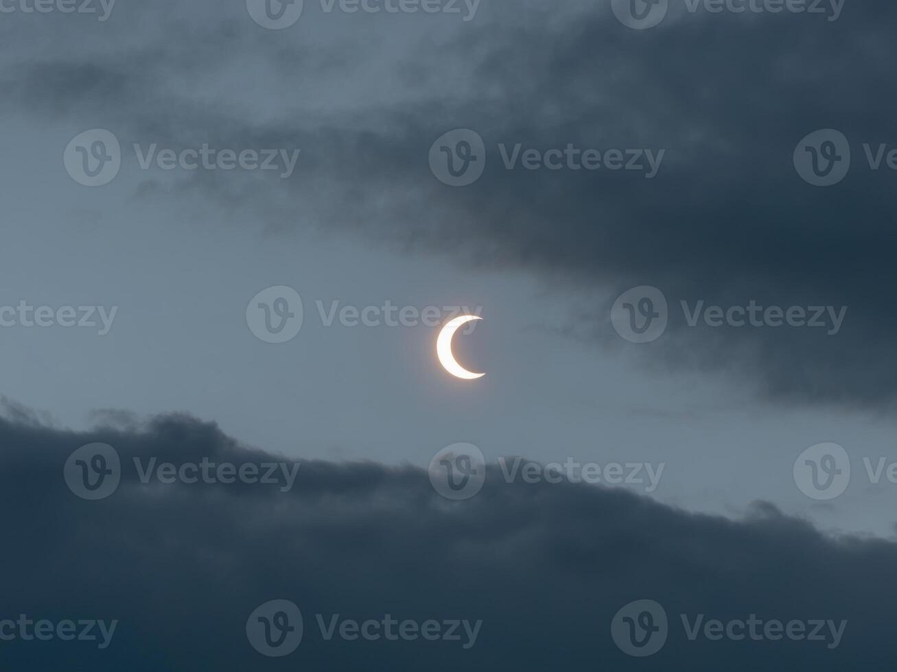 The moon is seen in the sky with a crescent photo
