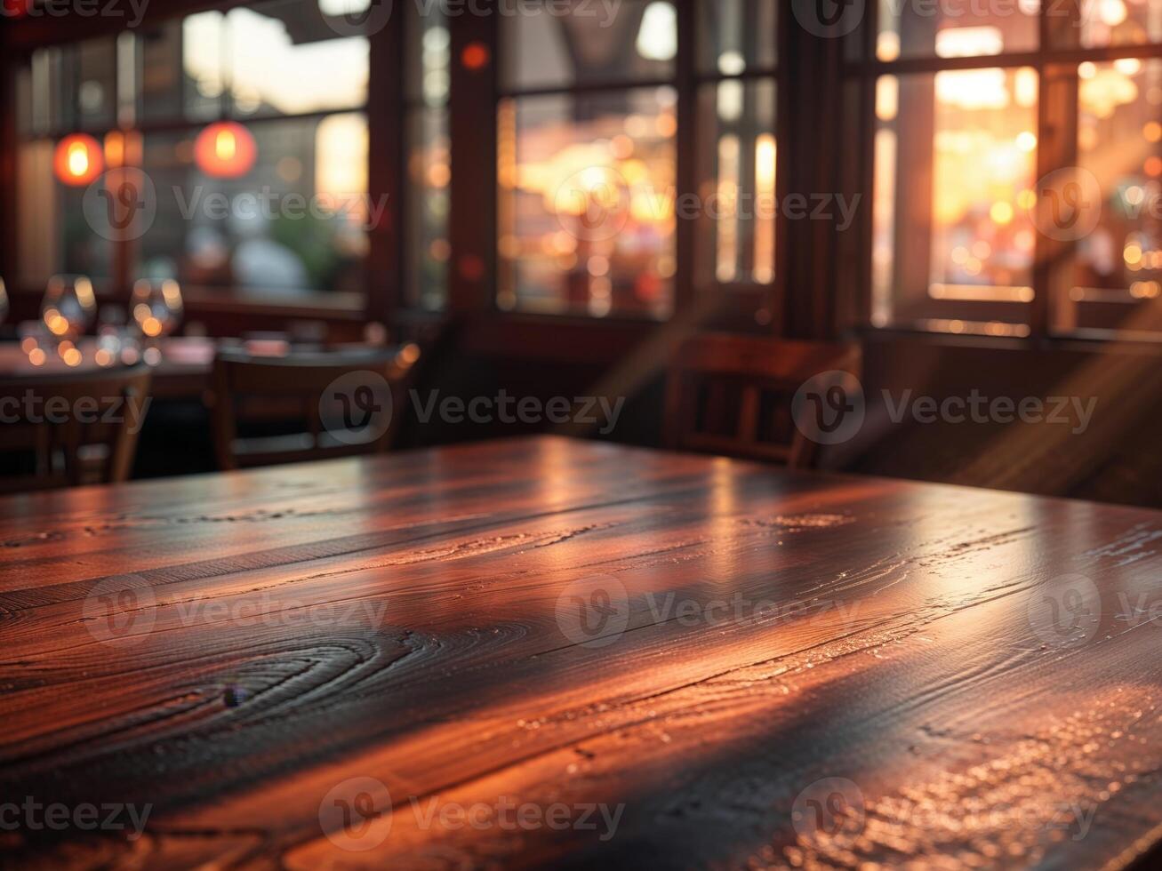 Dark wooden table at a restaurant with blurred background during sunset hours photo