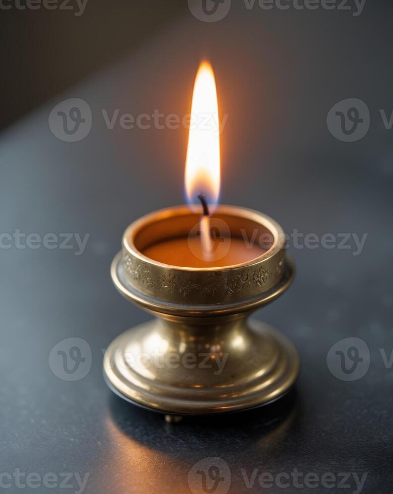 Close Up of Flickering Candle in Brass Holder on Stylish Table Surface photo