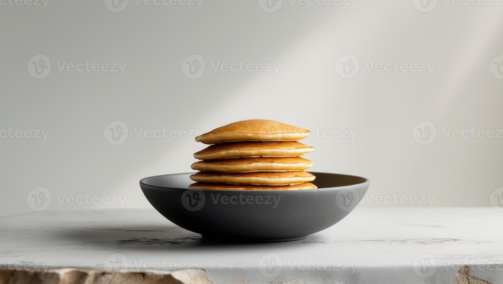 Stack of pancakes in a bowl on a table photo