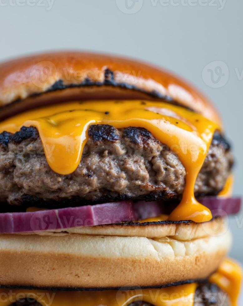A close up of a cheeseburger with cheese and onions photo