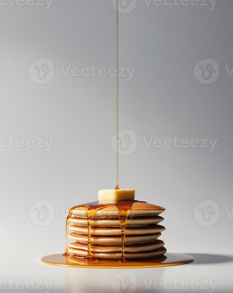 A stack of pancakes with syrup being poured over them photo