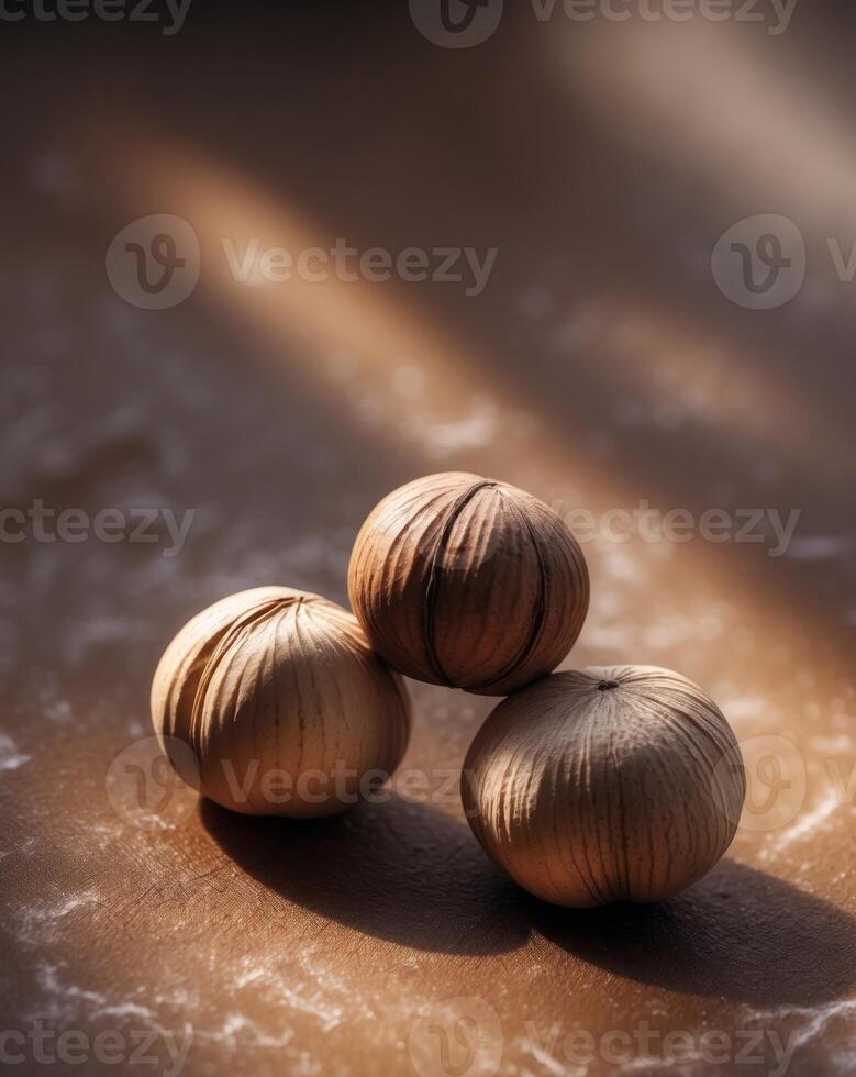 A close up of three hazelnuts on a brown surface photo