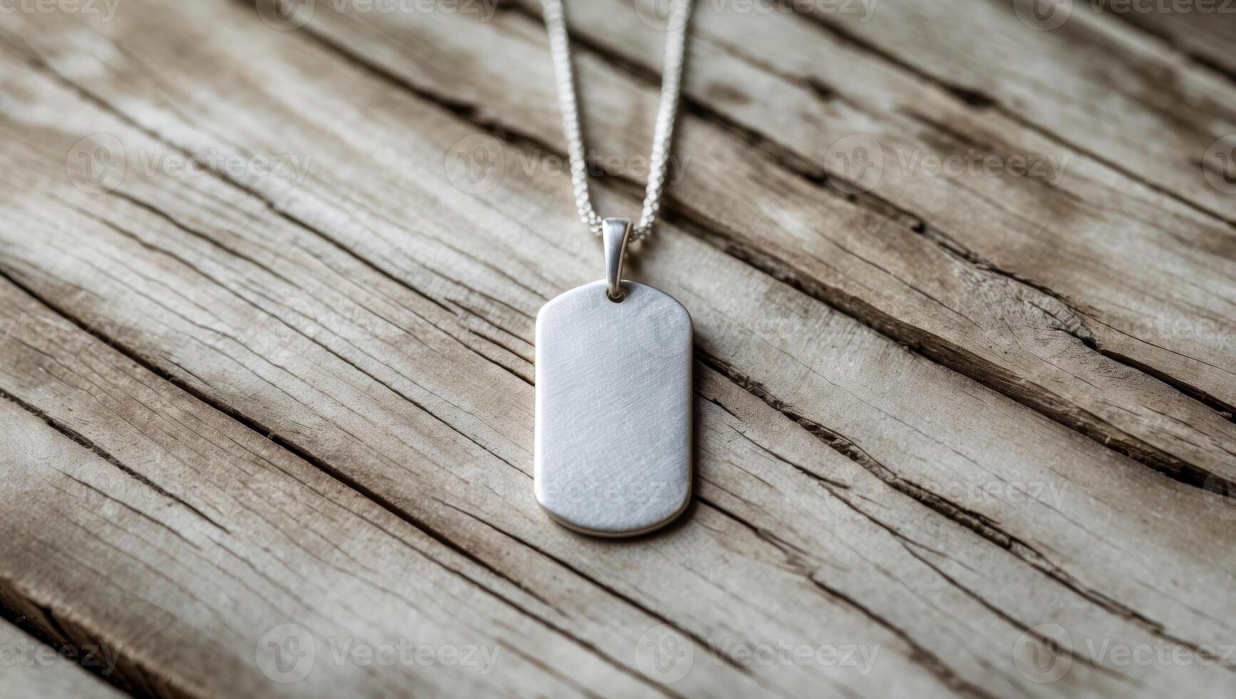 A silver dog tag necklace on a wooden table photo
