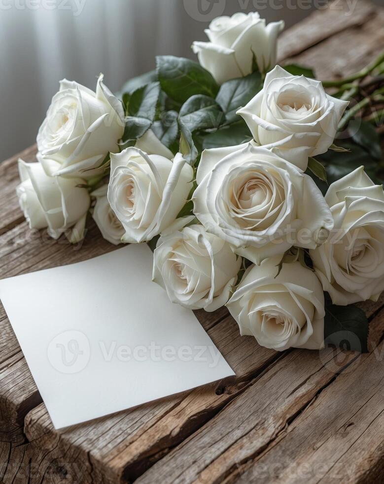 White roses arranged with a blank note on a wooden surface for special occasions photo