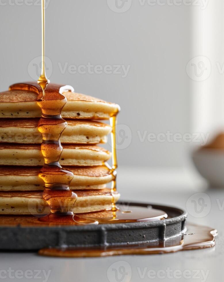 A stack of pancakes with syrup being poured over them photo