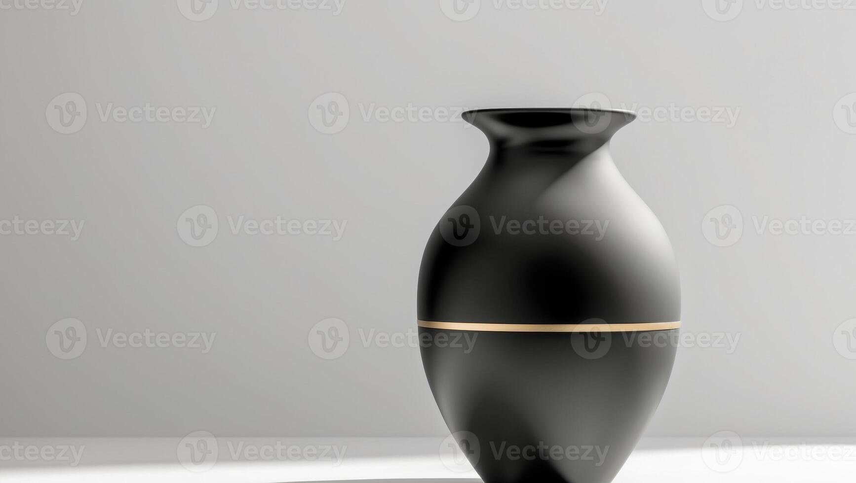 A black vase with gold trim on a white surface photo