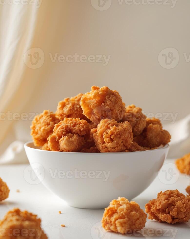 A bowl of fried chicken nuggets sitting on a table photo