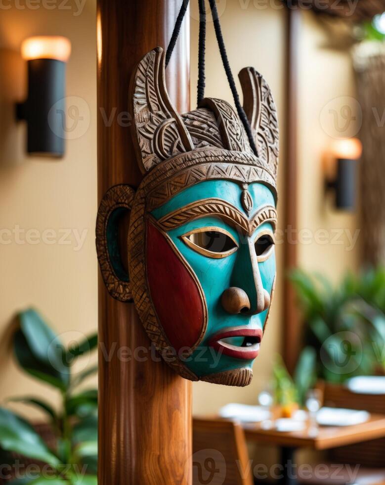 A wooden mask hanging from a wooden pole photo