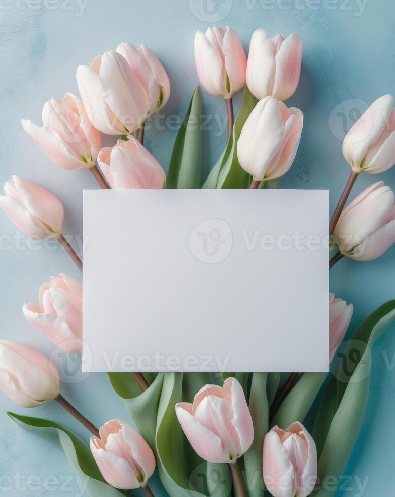Pink tulips and blank card on blue background top view photo