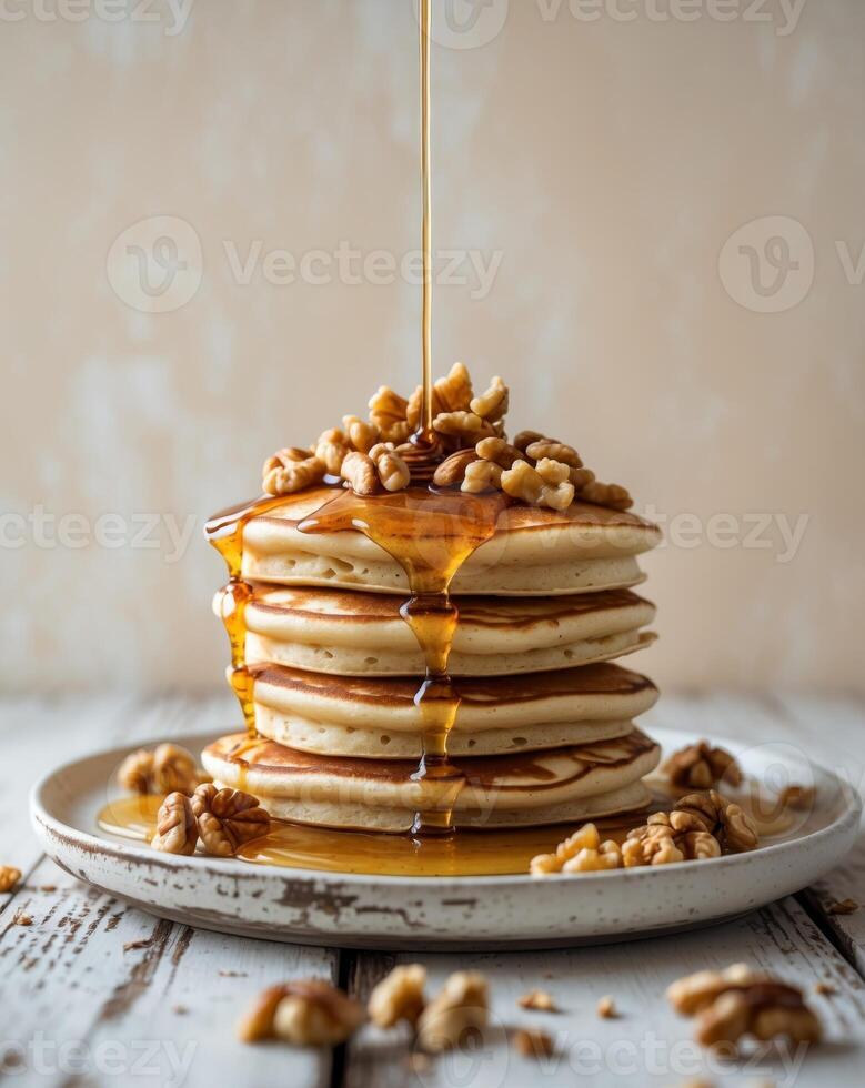 A stack of pancakes with walnuts and syrup photo