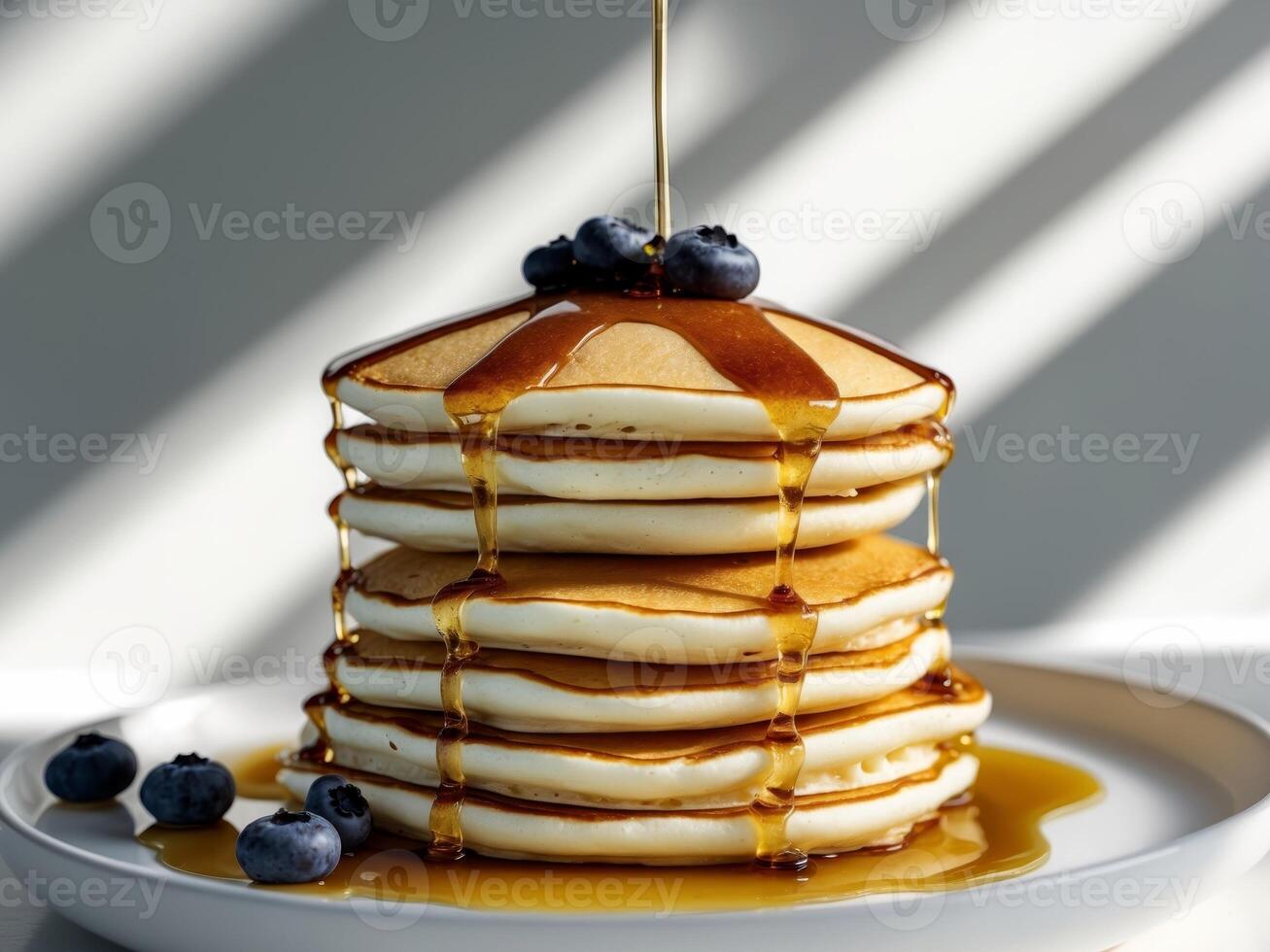 A stack of pancakes with syrup and blueberries photo