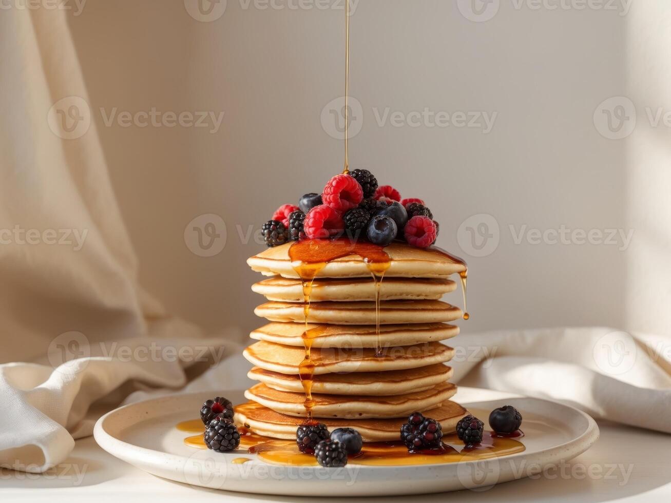 A stack of pancakes with syrup and berries photo