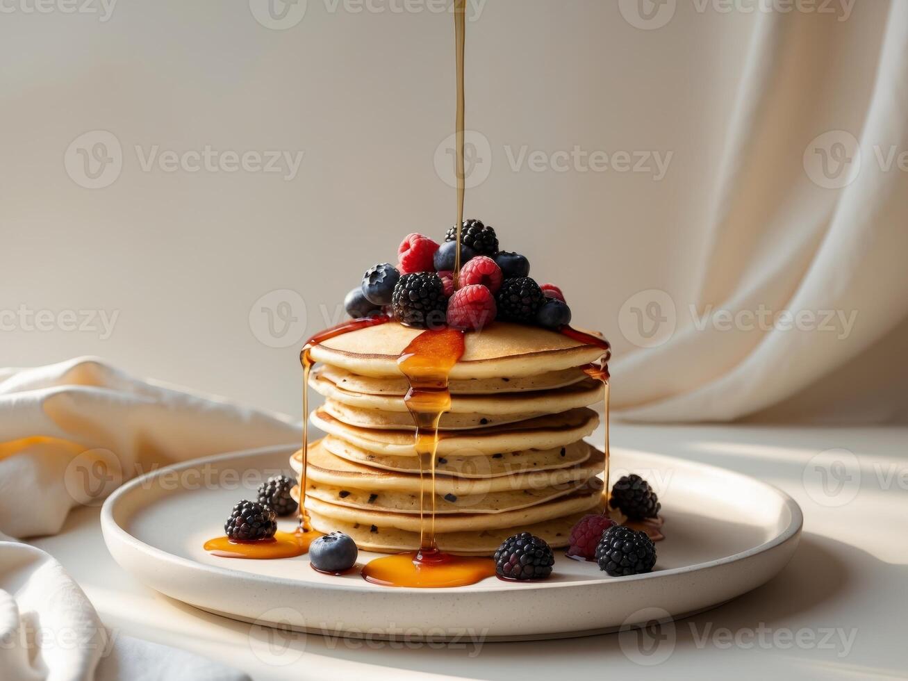 A stack of pancakes with syrup and berries photo
