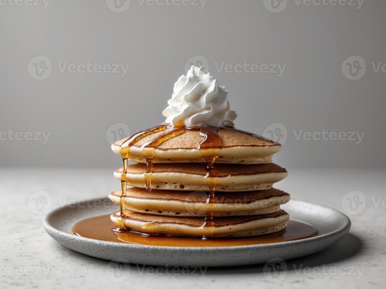 A stack of pancakes with whipped cream and syrup photo