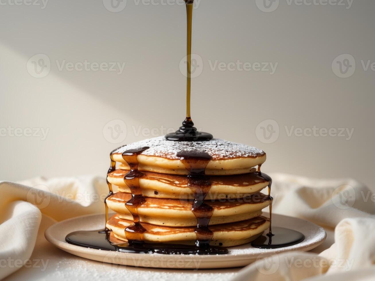 A stack of pancakes with syrup being poured over them photo