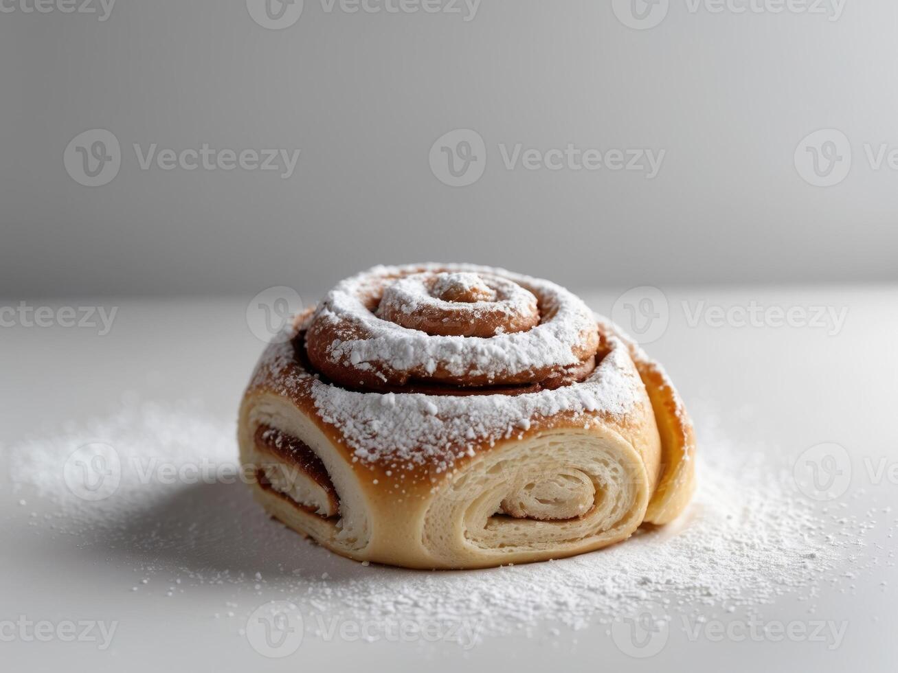 A cinnamon roll covered in powdered sugar photo