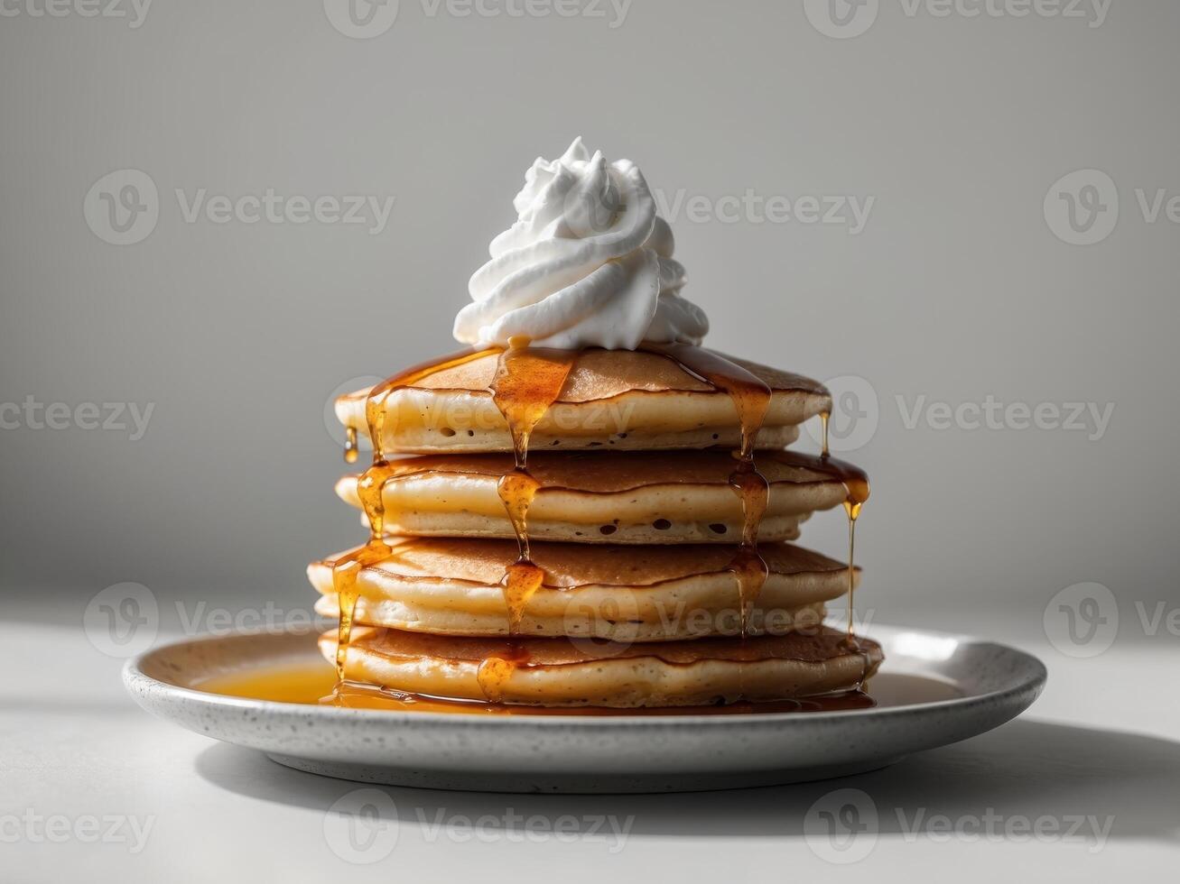 Delicious Stack of Pancakes Drizzled with Syrup and Cream photo
