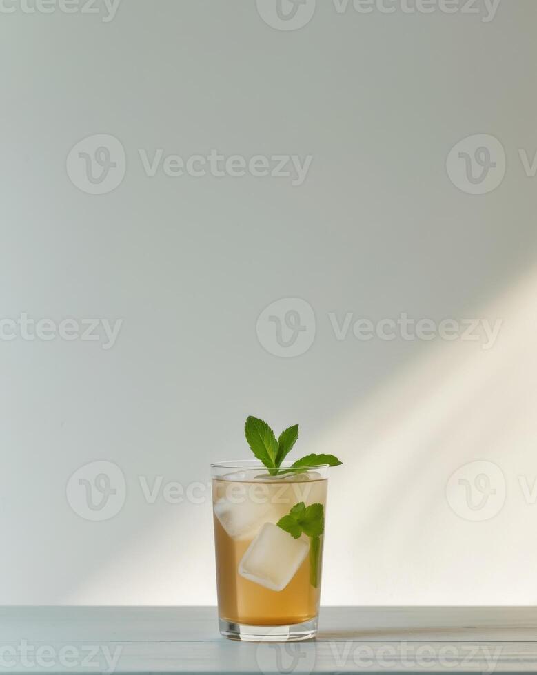 there is a glass of iced tea with ice cubes on the table photo