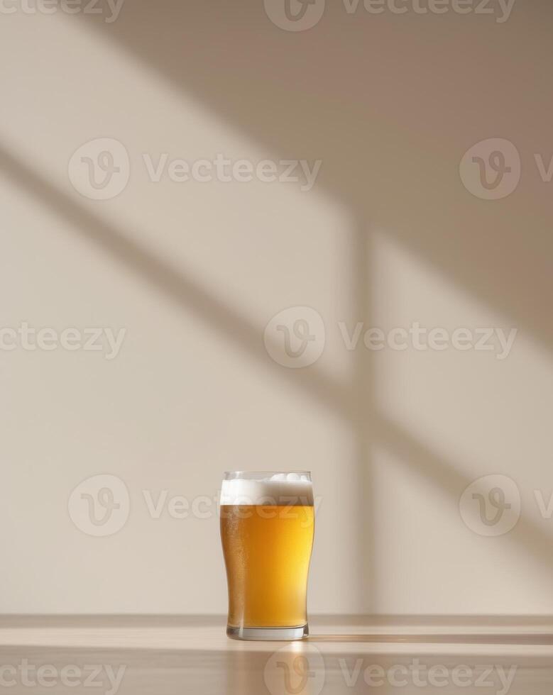 A glass of beer on a table in front of a wall photo