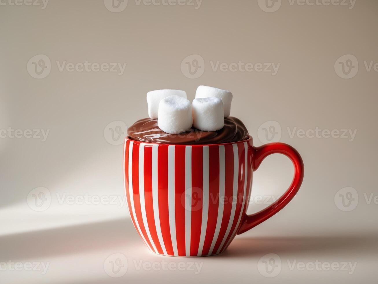 Hot chocolate with marshmallows in a red and white striped mug photo