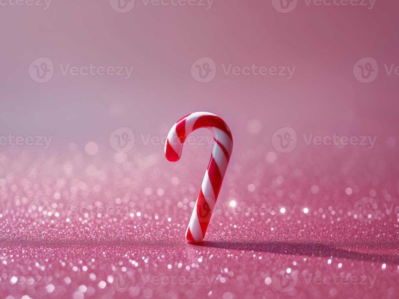 A candy cane on a pink background with sparkles photo