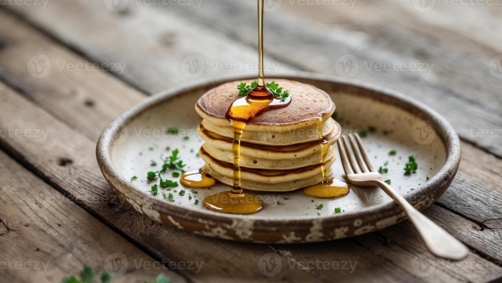 A stack of pancakes with syrup being poured on top photo