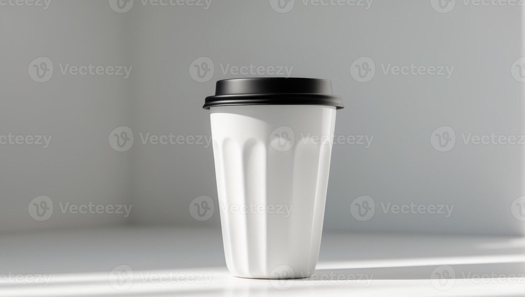 A white coffee cup with a black lid on a table photo