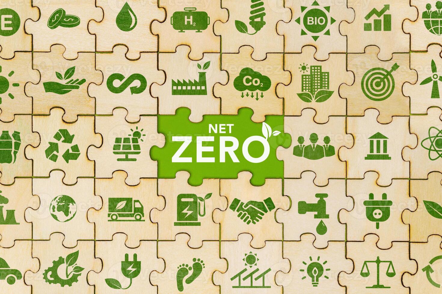 The concept of net zero and carbon neutrality Green net zero icon on wooden jigsaw puzzle For the goal of net zero greenhouse gas emissions Long term climate neutral strategy on green background photo