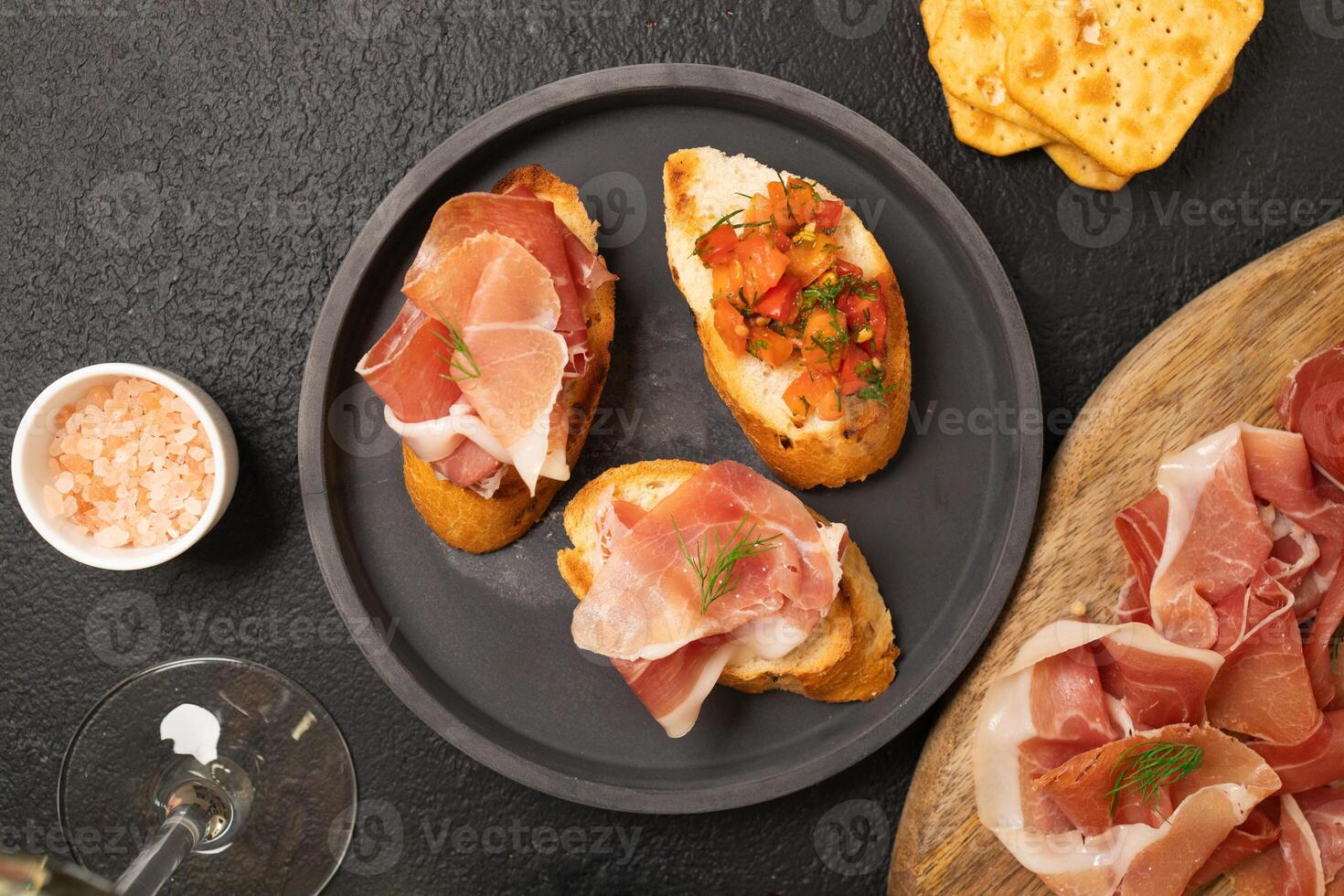 Tasty bruschetta served with wine on gray background photo