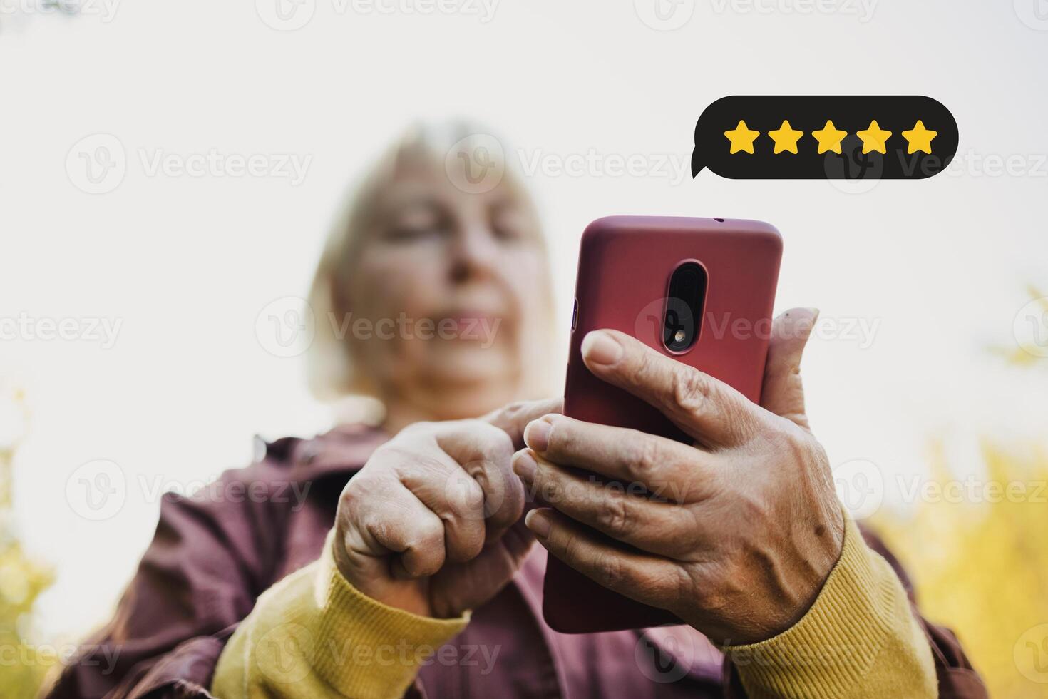 Customer Experience Concept. Excellent. Happy senior woman pressing face emoticon on virtual touch screen at smartphone .Customer service evaluation concept. photo