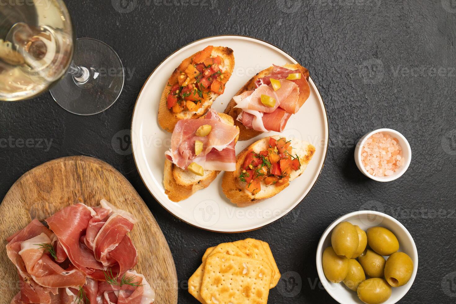 Tasty bruschetta served with wine on gray background photo